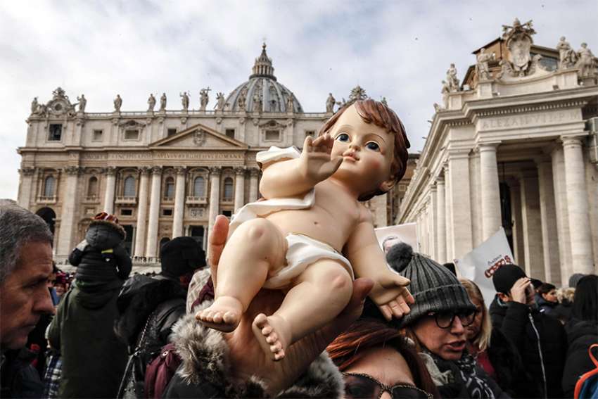  An audience member holds a figurine of baby Jesus as Pope Francis leads his Sunday Angelus prayer in St. Peter&#039;s Square at the Vatican Dec. 16. 