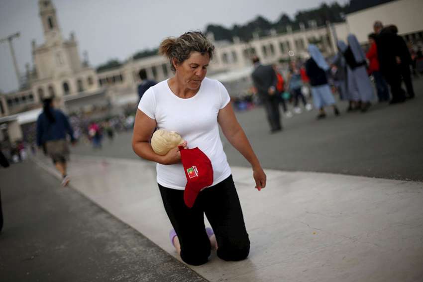 A pilgrim walks on her knees at the Marian shrine of Fatima in 2015 in central Portugal.