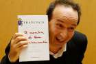 Italian actor Roberto Benigni holds a copy of the book, &quot;The Name of God Is Mercy,&quot; during its presentation to journalists in Rome Jan. 12. The book is compiled from an interview Pope Francis did with Italian journalist Andrea Tornielli. 