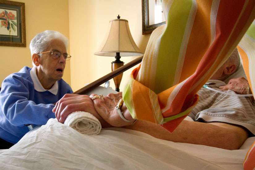 In this Sept. 7, 2012, file photo, family members watch over Leo King at his bedside at the Center for Compassionate Care in Pittsburgh. King, an 84-year-old urologist and veteran of World War II, died the following day with family at his side. Pictured is his sister Patricia King, left, and his wife, Jacqualin, right. 