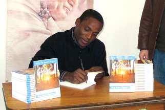 Fr. Victor Amole signs copies of his new book, Light Unto My Path: Forty Biblical Reflections.
