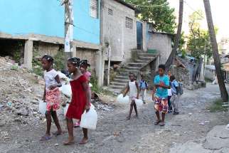 Children in Santo Domingo, Dominican Republic, carry containers for water Sept. 6 as Hurricane Irma races across the Caribbean. The hurricane was scheduled to hit the island later that night. 