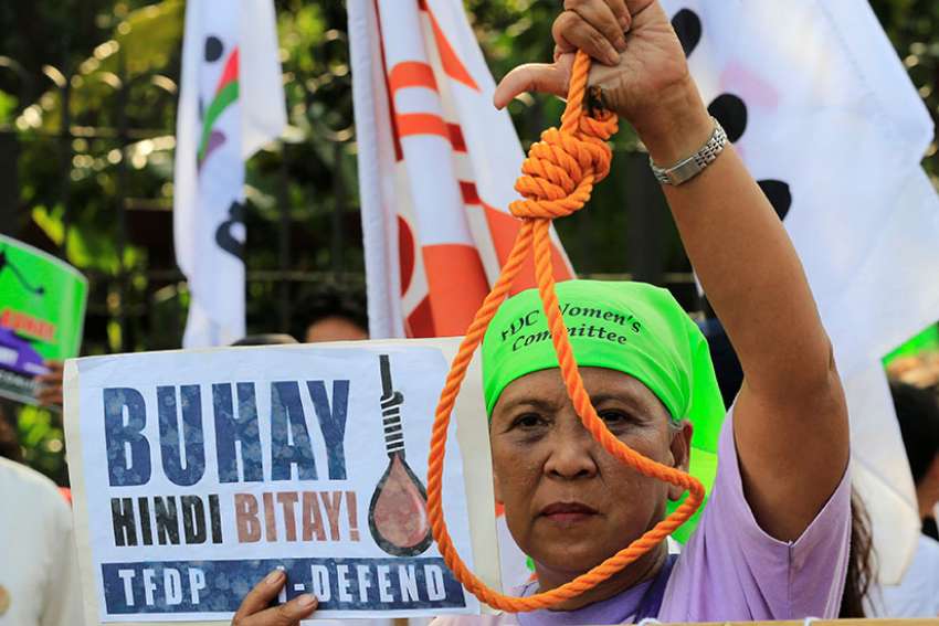 A woman holds up a noose during a Feb. 18 protest against plans to reimpose the death penalty, promote contraceptives and intensify the drug war at the Walk for Life in Manila.