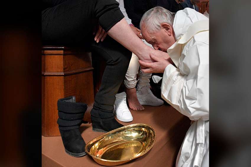 Pope Francis kisses the foot of an inmate April 13 at Paliano prison outside of Rome as he celebrates Holy Thursday Mass of the Lord&#039;s Supper. The pontiff washed the feet of 12 inmates at the maximum security prison.