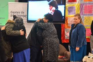 People console one another during the National Inquiry Into Missing and Murdered Indigenous Women and Girls public hearings in Edmonton, Alberta, Nov. 7