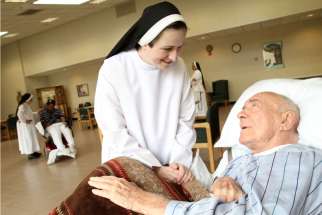 A palliative care patient chats with a sister in New York in this 2011 file photo. The Catholic Health Alliance of Canada is promoting palliative care as an option to assisted suicide, which is legal now after the Supreme Court struck down the ban.