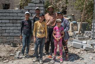 A Catholic family working to repair their family home damaged by Islamic State militants poses in 2017 in the Christian town of Karamdes, Iraq. 