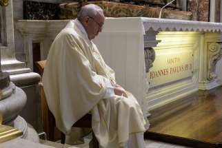 Pope Francis prays silently during Mass at the tomb of St. John Paul II in St. Peter&#039;s Basilica May 18, 2020, the 100th anniversary of the late pope&#039;s birth.