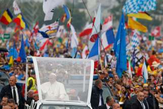 Pope Francis greets the crowd as he arrives for the World Youth Day welcoming ceremony in Blonia Park in Krakow, Poland, July 28.