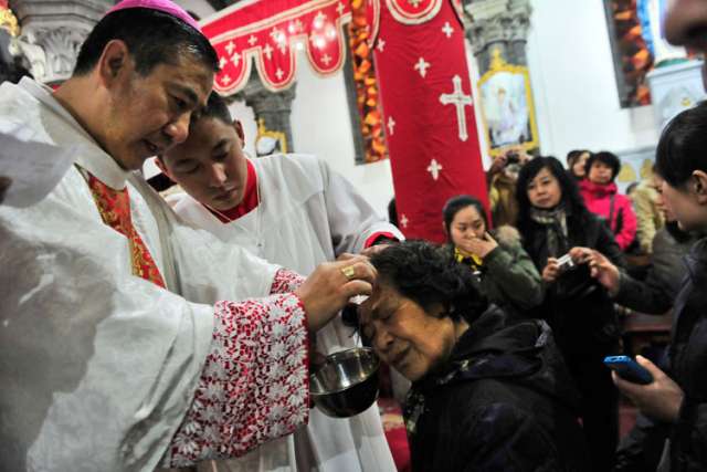 Chinese Catholic priests baptize new believers during a 2013 Easter Vigil in a church in Shenyang, China. A papal visit to China does not appear likely anytime soon, according to experts on the church in China.