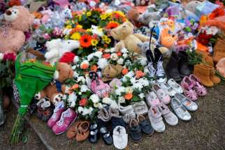 Children’s shoes line a memorial on the grounds of the former Kamloops Indian Residential School in Kamloops, British Columbia, June 6, 2021.