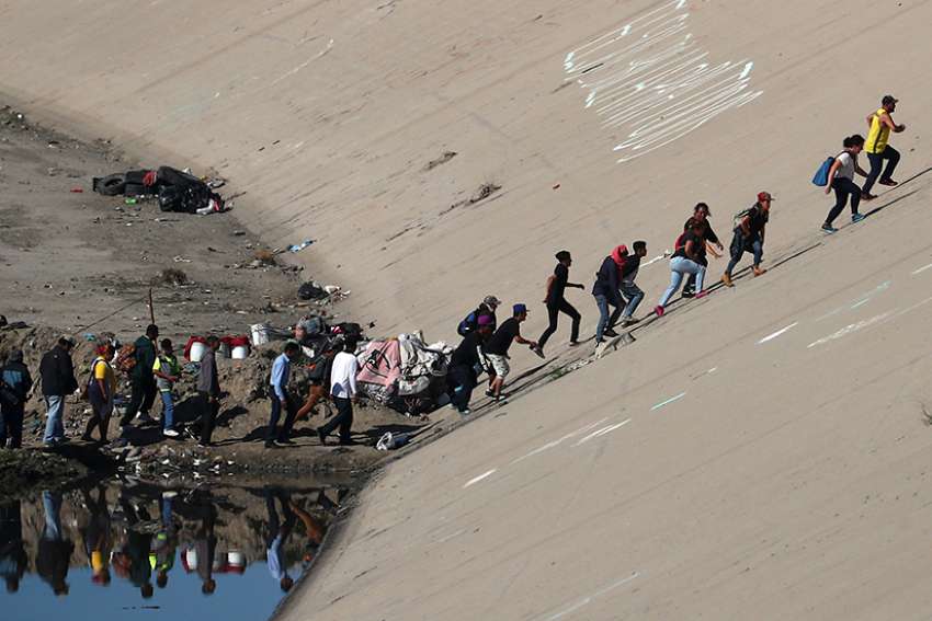 Part of a caravan of Central American migrants trying to reach the U.S. make their way to the border fence between Mexico and the United States Nov. 25 in Tijuana, Mexico.