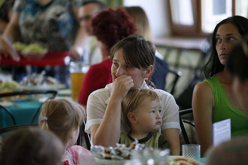A woman who fled fighting in Sloviansk, Ukraine, cries while holding a child at a shelter in the town of Makiyivka in eastern Ukraine June 4, 2014.