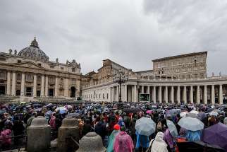 People stand in the rain as Pope Francis leads the Angelus from the window of his studio overlooking St. Peter&#039;s Square Nov. 4, 2018, at the Vatican.
