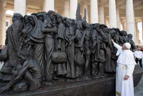 Pope Francis studies the bronze statue depicting migrants and refugees titled Angels Unawares by Canadian artist Timothy Schmalz.