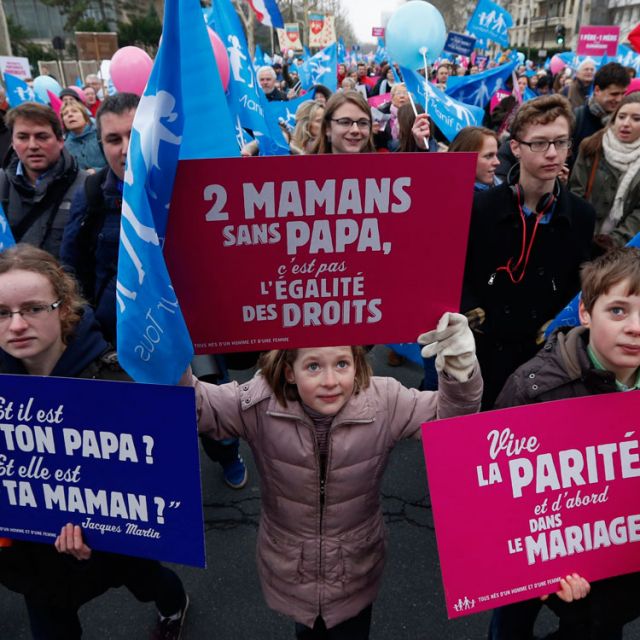Young people carry signs during a Jan. 13 protest against France’s planned legalization of same-sex marriage. The signs read “Where is your daddy, where is your mummy,” “Two mothers without a father, that’s not equal rights,” and “Long live equality, firstly, in marriage.”