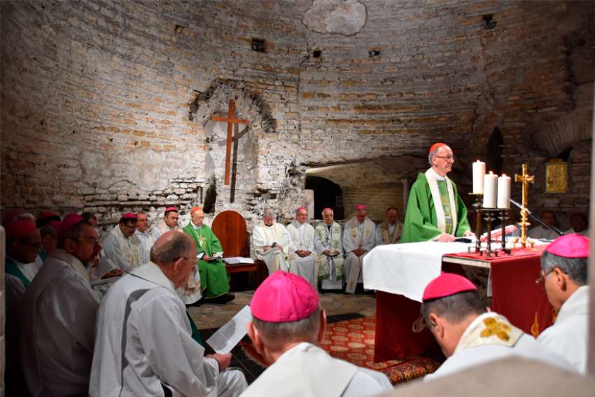 Brazilian Cardinal Claudio Hummes, relator general of the synod, and other participants in the Synod of Bishops for the Amazon celebrate Mass in the Catacombs of Domitilla in Rome Oct. 20, 2019. Several dozen synod participants at the Mass signed a pact promising to care for people and the earth and to give up a &quot;colonist mentality and posture.&quot;