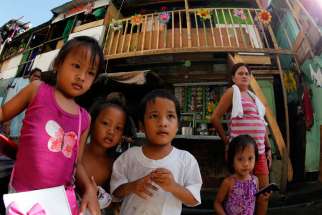 Children are seen next to shanties in Manila, Philippines, Nov. 17.