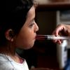 A nurse uses a syringe to give medicine to a girl at San Jose Hospice in Sacatepequez, Guatemala.