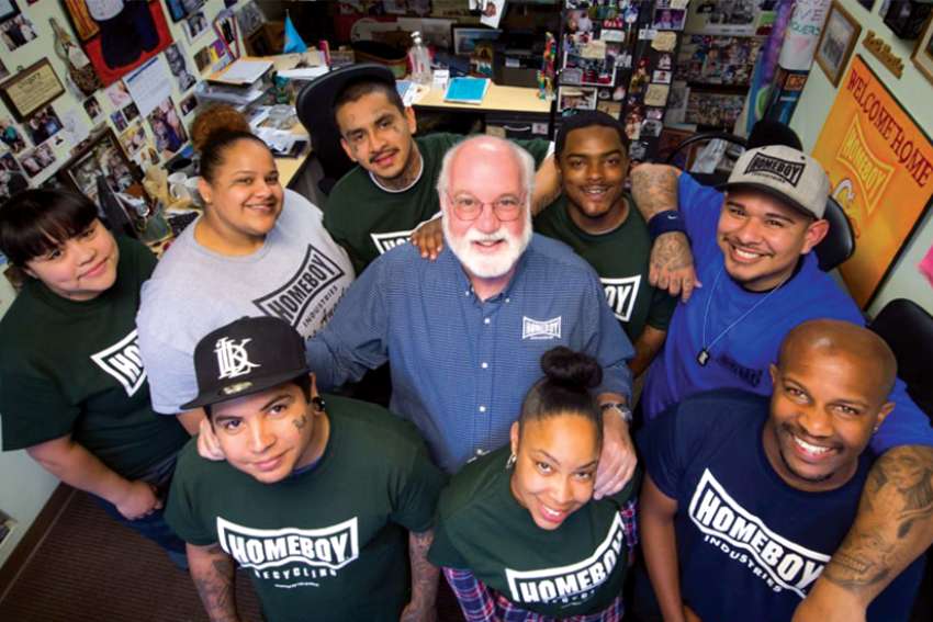 Jesuit Father Greg Boyle, founder of Homeboy Industries in Los Angeles, poses for a photo with trainees in this undated photo. He said he burned out at times in his ministry, something Deacon Kinghorn knows all too well in his ministry on Toronto’s streets.
