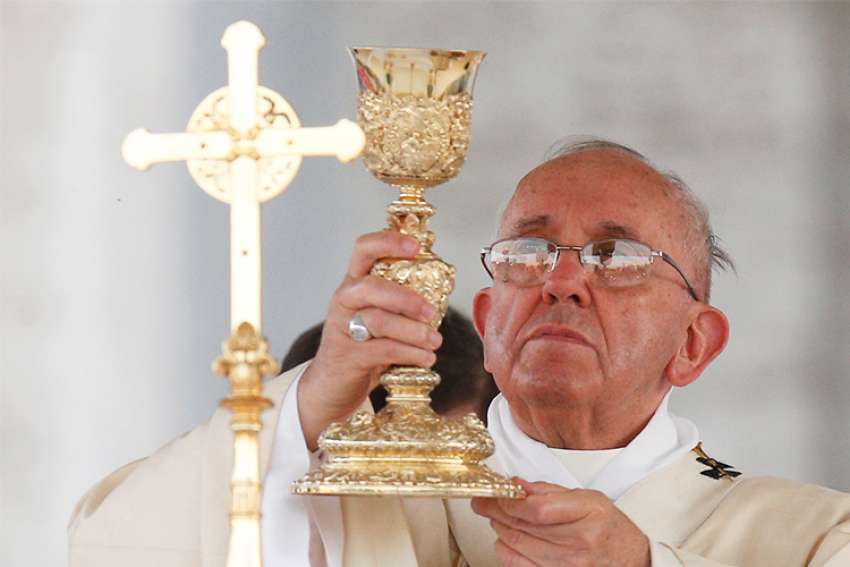Pope Francis elevates the chalice during Mass outside the Basilica of St. John Lateran in observance of the feast of Corpus Christi in Rome June 2015.