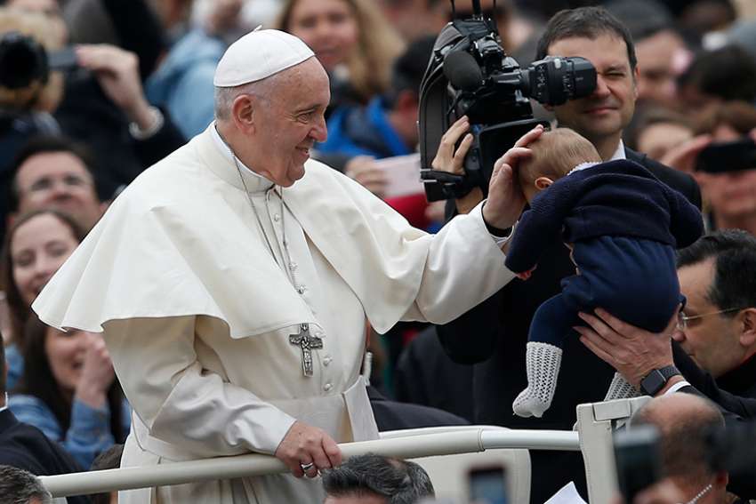 Pope Francis greets a baby during his general audience in St. Peter&#039;s Square at the Vatican April 11. 