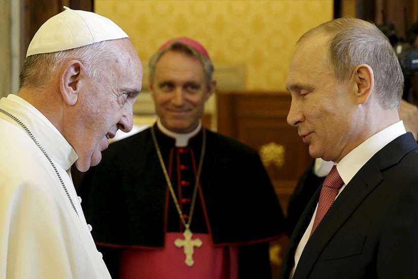 Pope Francis greets Russian President Vladimir Putin as he arrives for a private meeting at the Vatican June 10. At center is Archbishop Georg Ganswein, prefect of the papal household.