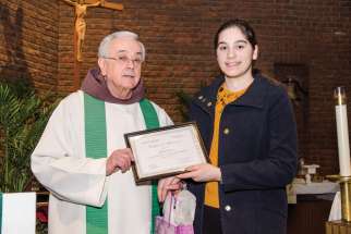 Fr. Damian MacPherson of the Franciscan Friars of the Atonement-Graymoor presents Raquel Seara with the second-place certificate from the annual essay contest for the Week of Prayer for Christian Unity. 