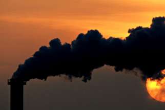 Smoke billows from a plant in late October at sunset in Wismar, Germany.