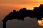Smoke billows from a plant in late October at sunset in Wismar, Germany.