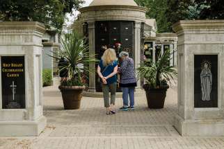 Two women take part in a July 29 tour of Mount Hope Cemetery in Toronto where they received a history lesson on the city’s Catholic past. Many prominent Catholics are buried in the grounds of Mount Hope.