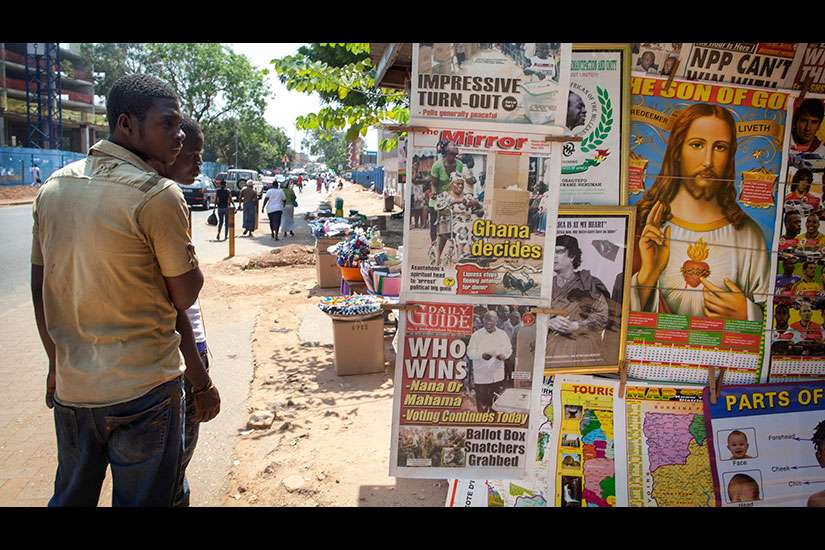 Men in Accra, Ghana, look at a newspaper stand in this Dec. 8, 2012, file photo. West African bishops urge Catholics to defend traditional marriage as influences from other nations are offered as keys to development.