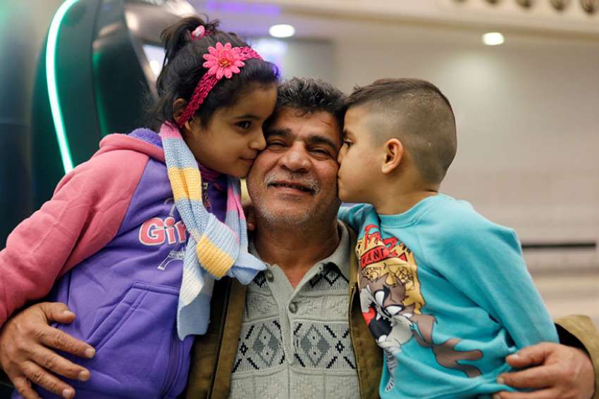 Nizar al-Qassab, an Iraqi Christian refugee from Mosul, gets a kiss from his children as they prepare to depart from Beirut international airport Feb. 8 en route to the United States. A three-panel federal appeals court upheld a temporary restraining order against President Donald Trump&#039;s refugee and travel ban.