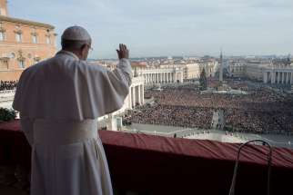 Pope Francis greets the crowd after delivering his Christmas message and blessing  ‘urbi et orbi’ (to the city and the world) from the central balcony of St. Peter&#039;s Basilica at the Vatican Dec. 25.