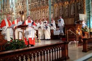 Cardinals (from left) Marc Ouellet, Thomas Collins and Gerald Lacroix read the prayer of consecration on Sept. 27 at Notre Dame Cathedral in Ottawa.