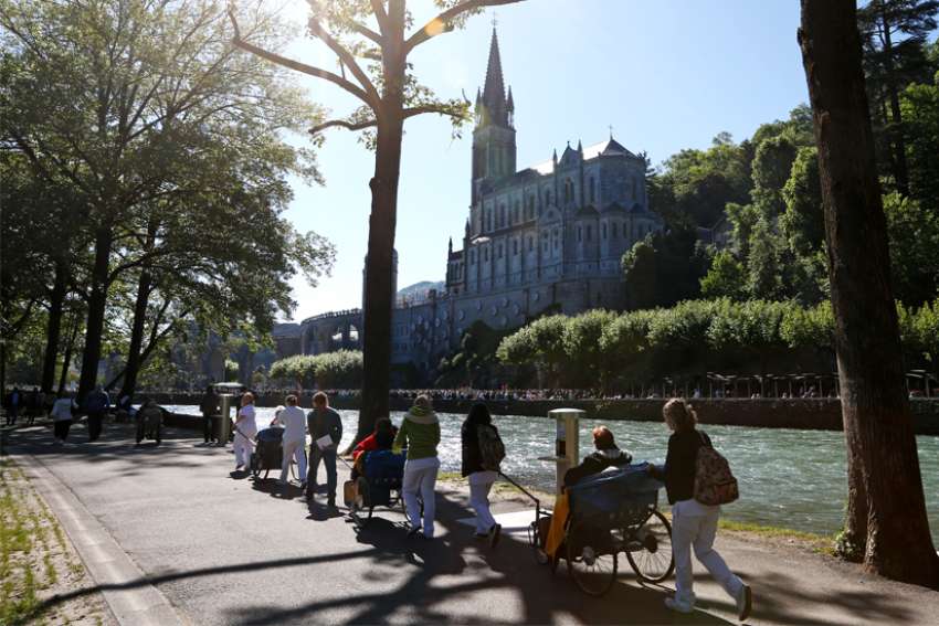Caregivers push the sick and disabled at the Shrine of Our Lady of Lourdes in southwestern France in this May 16, 2014, file photo. Pope Francis has appointed a special delegate for the pastoral care of pilgrims at the Lourdes shrine. 