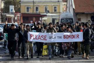Refugees and migrants hold a banner and shout slogans Nov. 11 as they walk toward the Croatian border in Belgrade, Serbia. English Cardinal Vincent Nichols said some British media stirred up xenophobic sentiments against migrants and refugees.