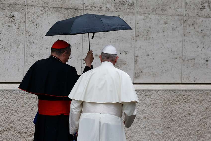  Pope Francis and Cardinal Oscar Rodriguez Maradiaga of Tegucigalpa, Honduras, share an umbrella as they leave a session of the Synod of Bishops on young people, the faith and vocational discernment at the Vatican Oct. 11. 
