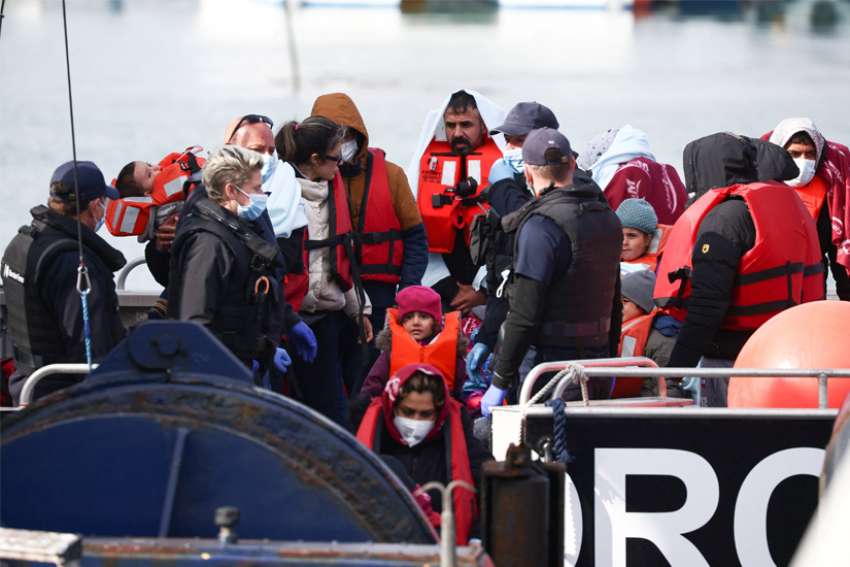 Migrants are escorted by military personnel after being rescued while crossing the English Channel in Dover, England, May 1, 2022. English and Welsh bishops said the U.K. government is unfairly punishing the migrants for the crimes of trafficking gangs by sending the them to Rwanda to have their asylum applications processed.