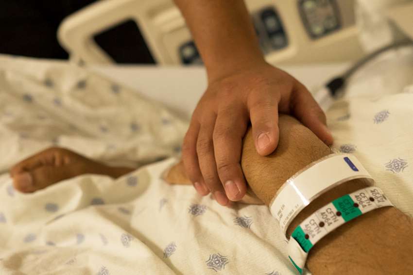 Hand of seminarian William Carmona in an intensive care room at Christus Santa Rosa Medical Center in San Antonio Sept. 7, 2014. 