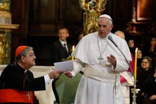 Pope Francis hands his speech to Cardinal Crescenzio Sepe of Naples, Italy, after deciding to speak off the cuff during a meeting with religious at the cathedral in Naples March 21.