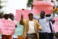Men carry signs in Kampala, Uganda, Feb. 24, as they celebrate a new anti-homosexuality law. Uganda&#039;s Catholic bishops reaffirmed their opposition to homosexuality, but reserved judgment on the bill, which imposes harsh punishment for homosexual acts.
