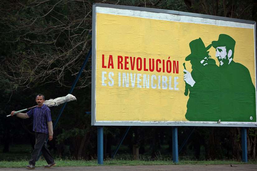 A man walks past a Cuban revolutionary billboard in Havana Dec. 26, 2014, reading &quot;The Revolution is Invincible.&quot; Pope Francis played a key role in restoring U.S.-Cuban diplomatic ties.