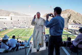 A man takes a photo of a life-size cutout of Pope Francis at the Sun Bowl in El Paso, Texas, Feb. 17. Thousands filled the stadium to watch Pope Francis celebrate Mass in nearby Ciudad Juarez, Mexico. It was simulcast on the stadium&#039;s big screen.