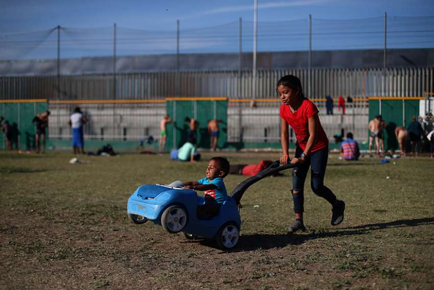  Children from Central America, part of the migrant caravan traveling to the U.S., play Nov. 18 in front of the border wall in Tijuana, Mexico.