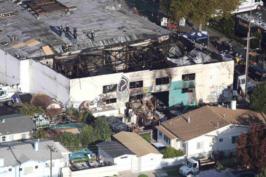 Recovery teams examine the charred remains of a two-story converted warehouse Dec. 4 in Oakland, Calif. A blaze at the building Dec. 2 claimed the lives of at least 33 people. 