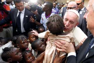Pope Francis kisses a child as he visits a refugee camp in Bangui, Central African Republic, Nov. 29