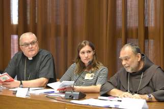 Emilie Callan, center, a synod delegate from Canada, attends a working group at the Synod of Bishops on young people, the faith and vocational discernment at the Vatican Oct. 10. 
