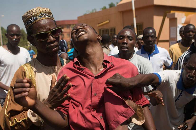 An anti-government protester is helped after being shot in Ouagadougou, Burkina Faso, Oct. 30. Burkina Faso&#039;s Catholic bishops sent a &quot;message of peace and hope&quot; to the West African country after its 27-year president, Blaise Compaore, fled prompting a m ilitary takeover.